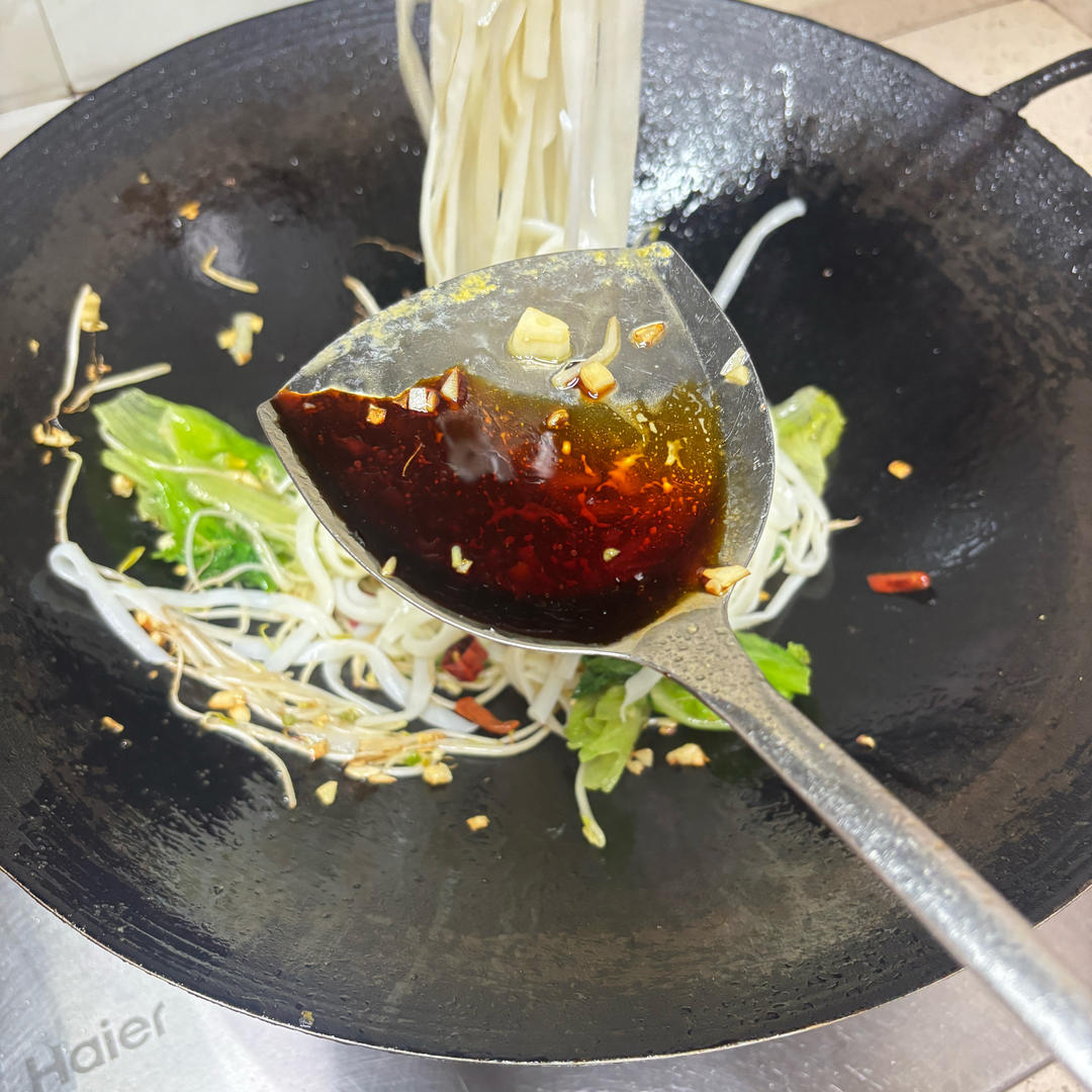 Adding light soy sauce to the noodles