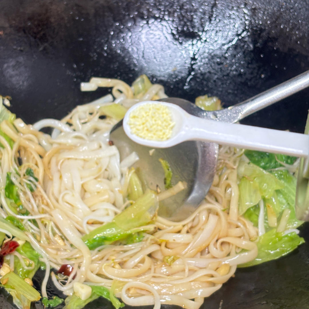 Sprinkling chicken bouillon powder over the noodles