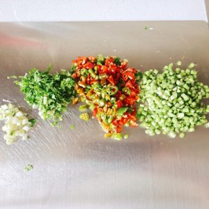 Chopped garlic chives, chiles, cilantro, and scallions in small bowls