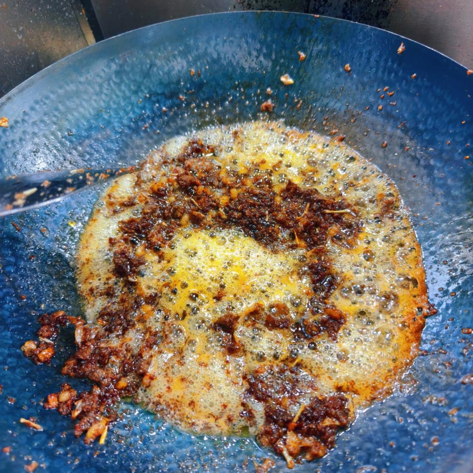 Seasoned minced pigeon turning glossy and dry in the wok