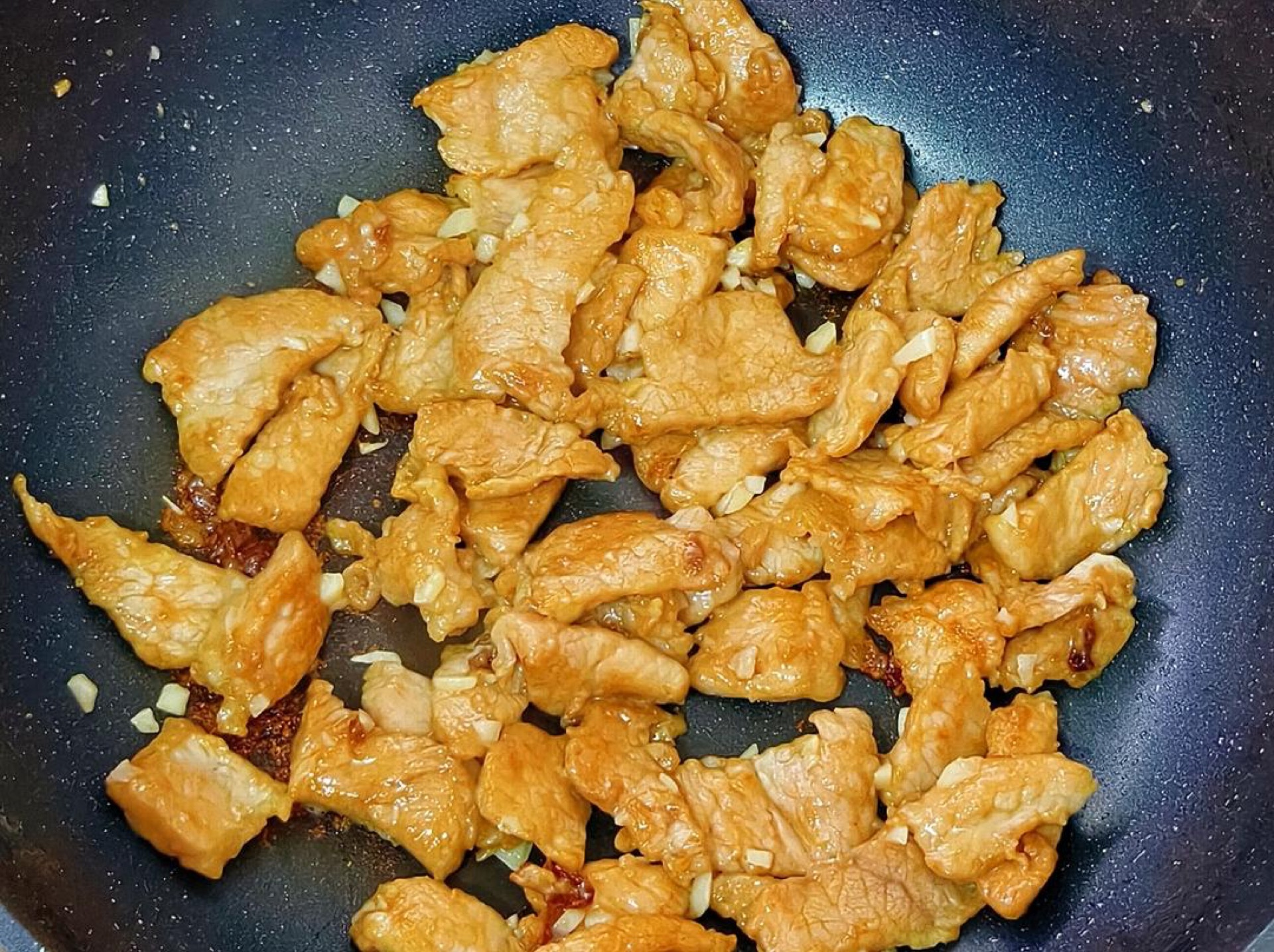 Heat oil, add the pork slices and stir-fry until they change color, then add the minced garlic and stir until fragrant.