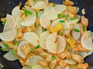 Add the radish back in and stir-fry everything evenly, then scatter over the chopped scallions and serve.