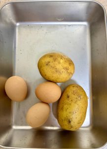 Prepare 2 small potatoes and 3 free-range eggs. Peel the potatoes and cut them into thin julienne strands. Crack the eggs into a bowl and beat them until smooth.
