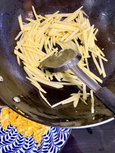 Heat vegetable oil in the wok and scramble the eggs first, then scoop them out and set them aside. Pour the potato strands into the remaining oil in the wok and stir-fry them for a