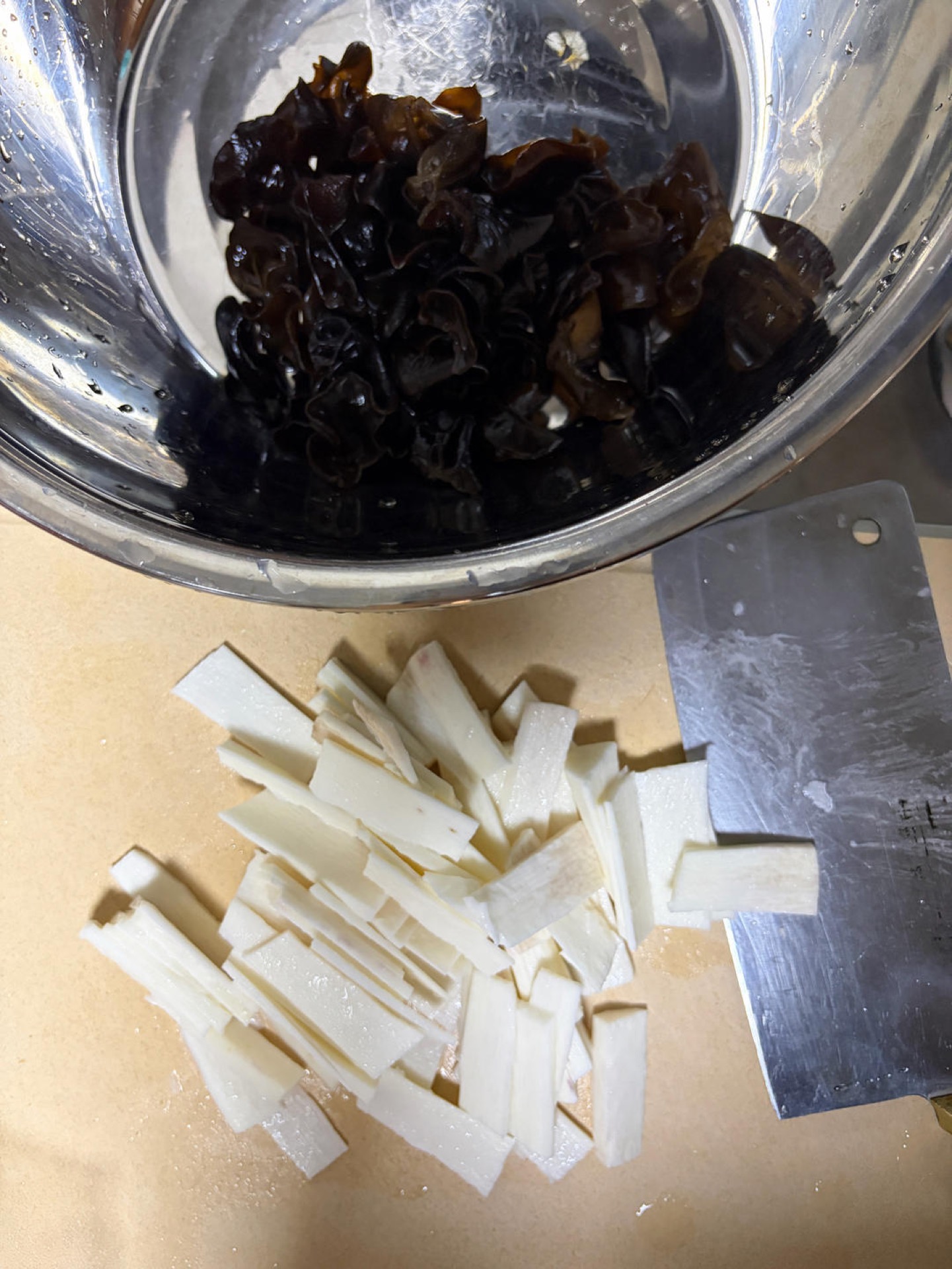 Soak the black fungus in hot water for ten minutes, rinse it clean, and drain off the water; peel and wash the Chinese yam and cut it into thin slices (wear kitchen gloves to preve