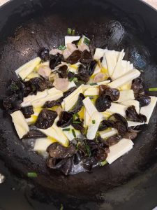 Add the yam and stir-fry for a dozen tosses, pour in a small bowl of hot water, season with salt and sugar, cover with a lid, and simmer over low heat for about 3 minutes.