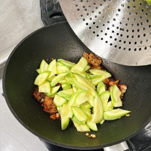 Add the zucchini to the wok.