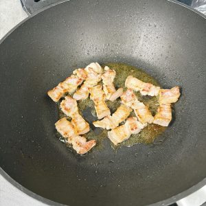 Fry the pork belly until it renders its fat and the edges turn golden.