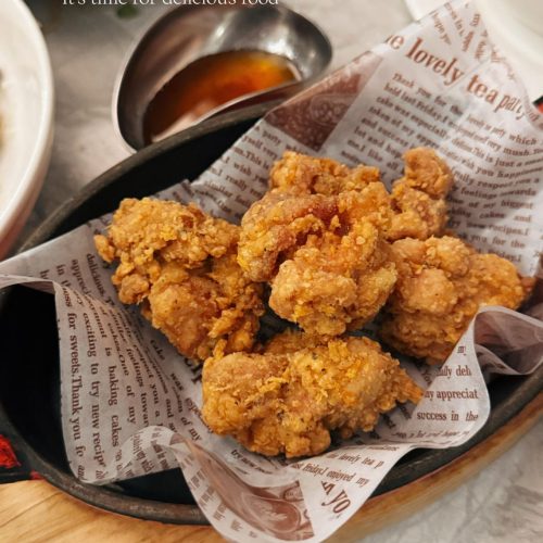 Taiwanese salt and pepper chicken piled on paper with fried basil and pepper salt