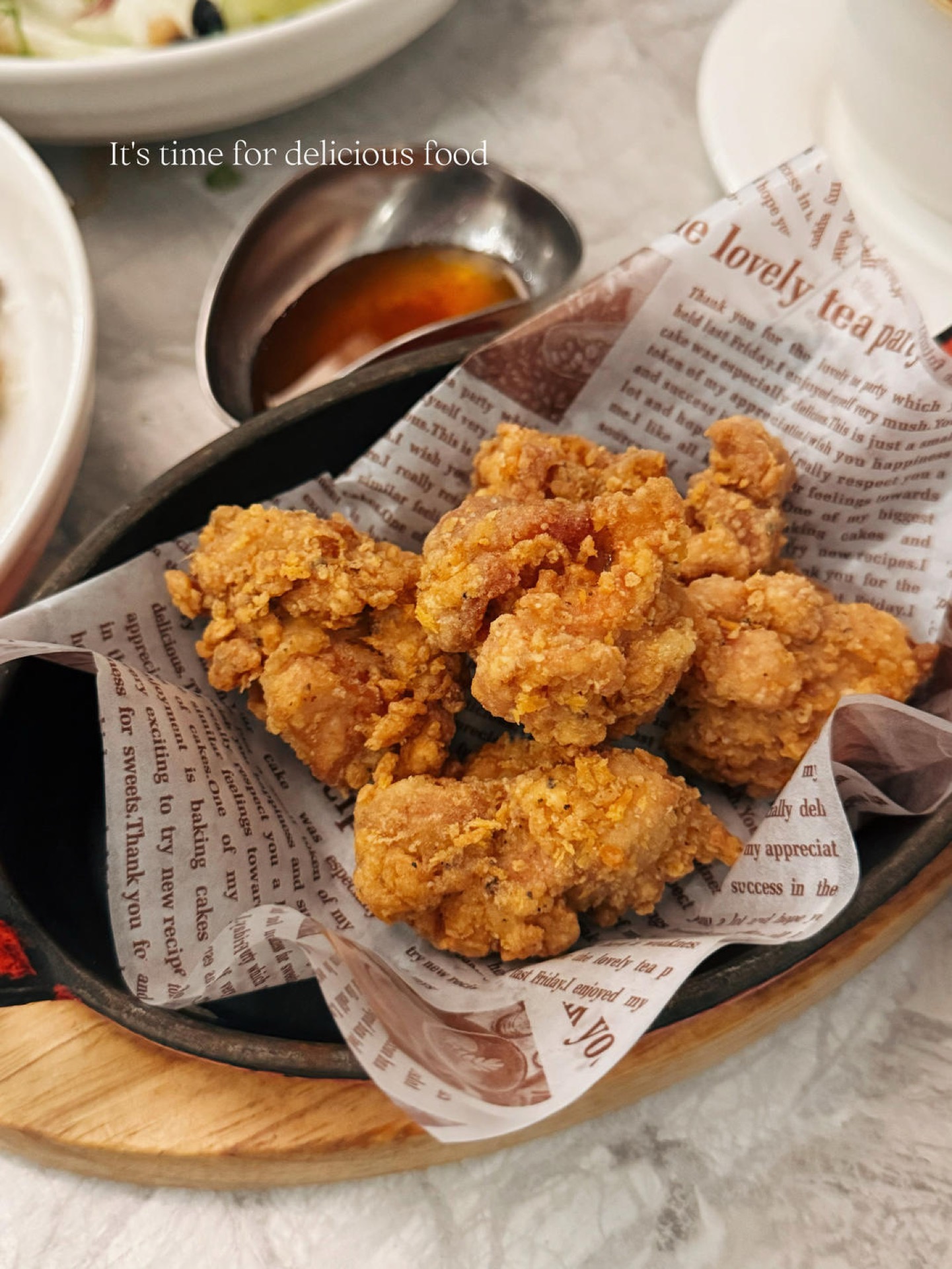 Taiwanese salt and pepper chicken piled on paper with fried basil and pepper salt