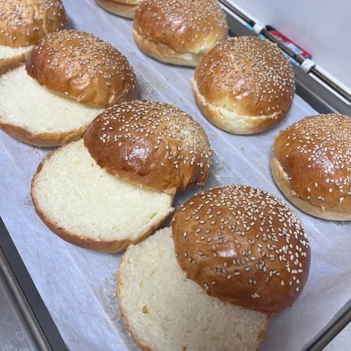 Golden sesame-dotted tangzhong burger buns fresh from the oven