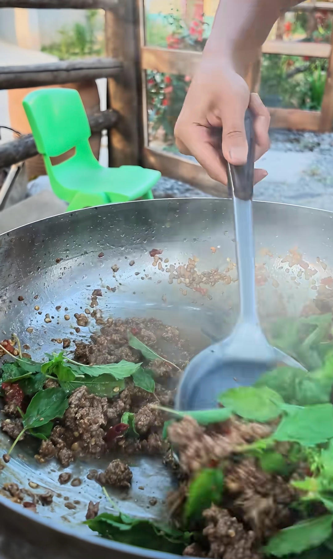 Folding Thai basil leaves into the pork