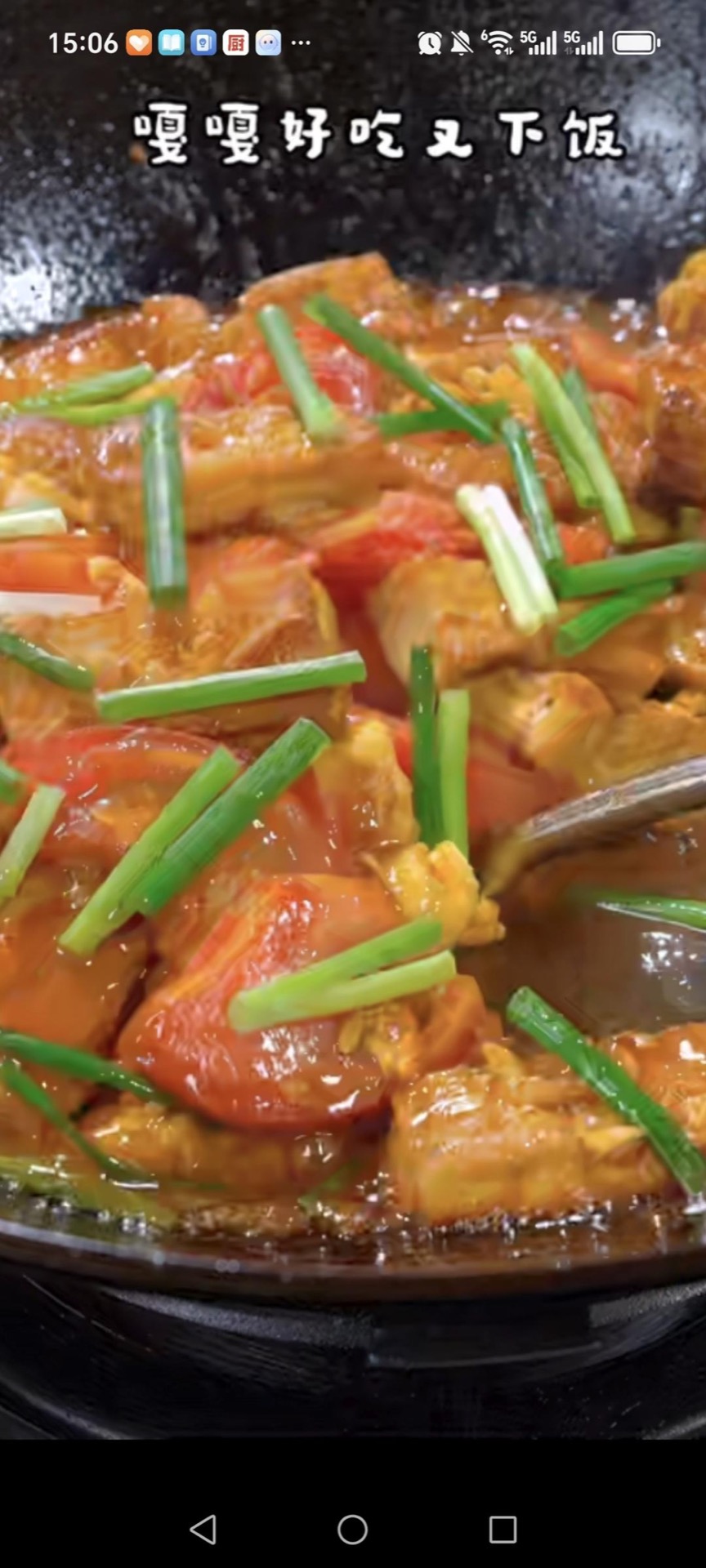 Tomato braised tofu with eggs in a wok, golden tofu cubes and tomato wedges coated in glossy red sauce