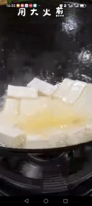 Add the tofu cubes to the pan and fry them gently.