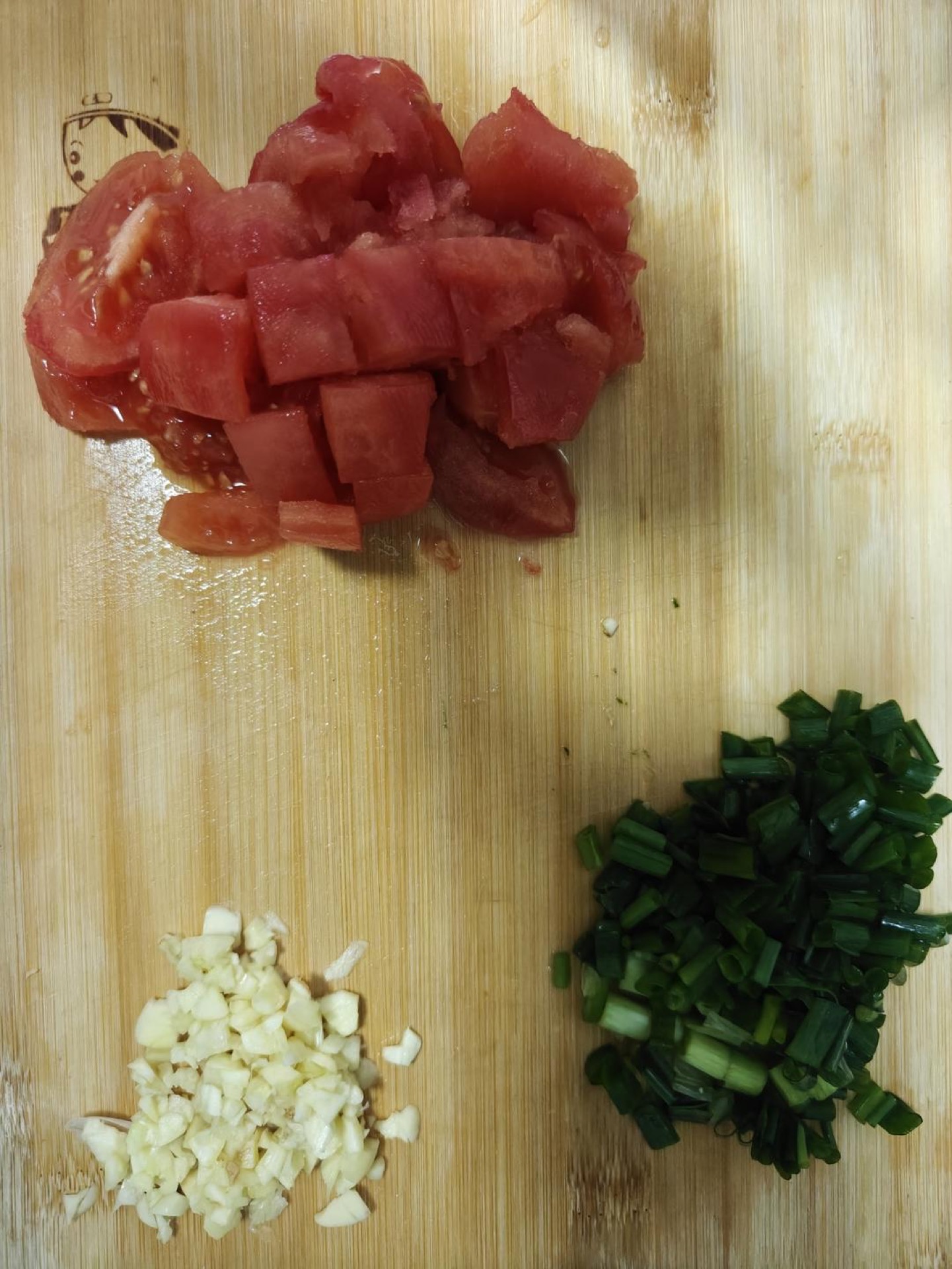 Dice the tomatoes into 1/2-inch cubes, mince the garlic, and finely chop the white parts of the scallions while slicing the green parts on the bias.