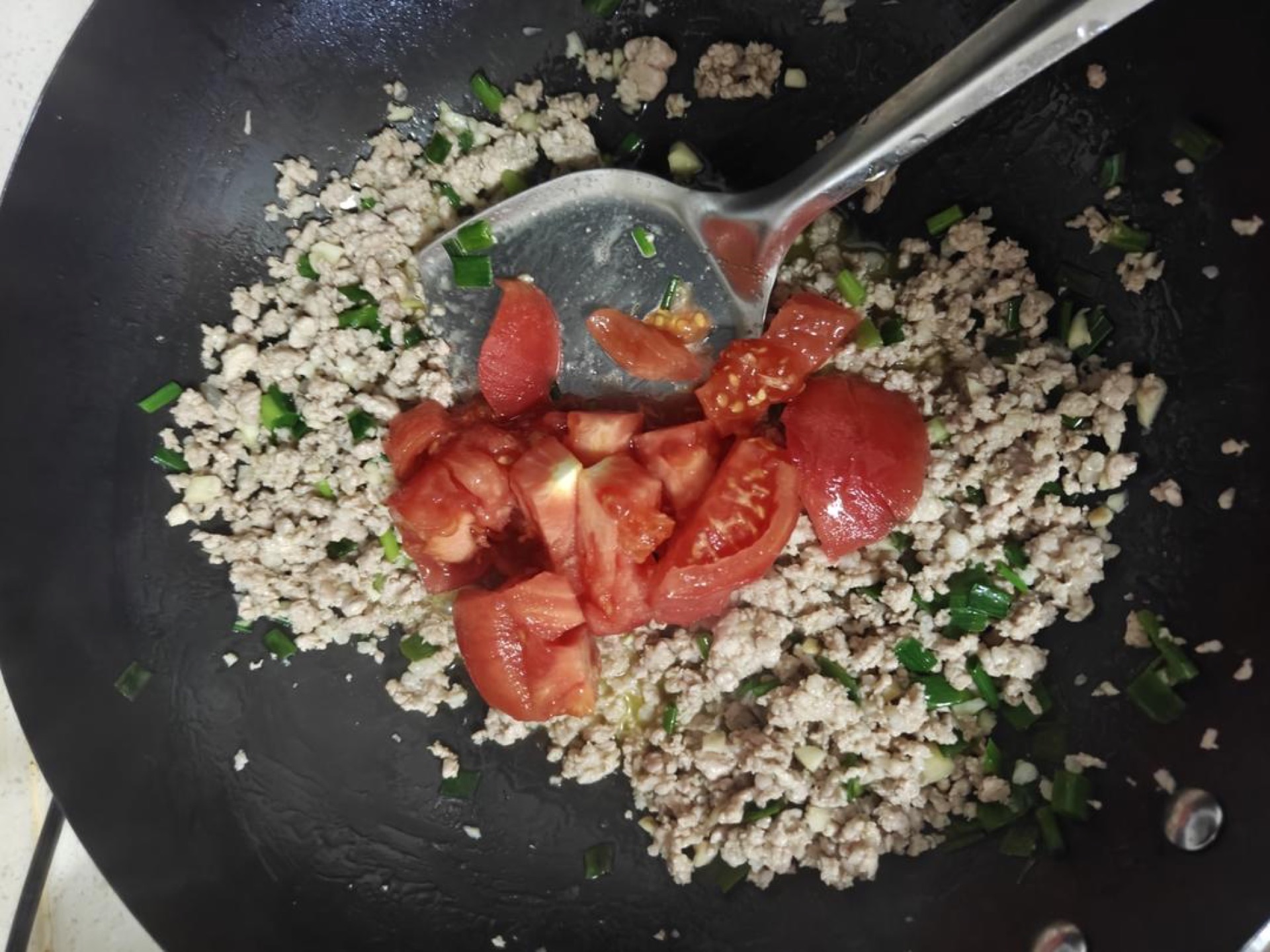 Tip in the diced tomatoes and stir to combine with the pork.