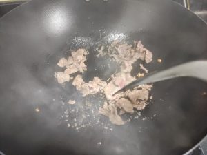 Add the ginger, garlic, and chili to the wok and fry until fragrant, then add the pork slices and stir-fry over high heat until nearly cooked through, then transfer to a plate.