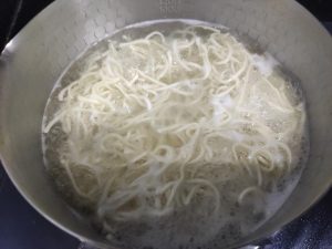 Boil the noodles until half-done first (they really must be half-done, or they will turn mushy after stir-frying), then rinse them under cold water.