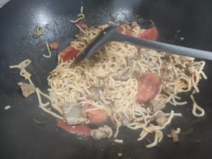 Add about 30 g of water to the wok, add the noodles, and simmer until only a little sauce remains, then add the pork slices and cook until the liquid is gone and the pork is cooked