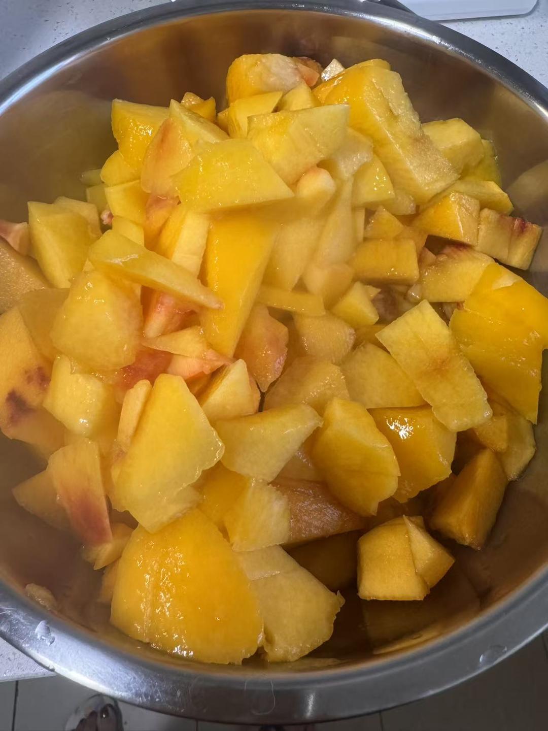 Peeled yellow peaches cut into small pieces on a cutting board