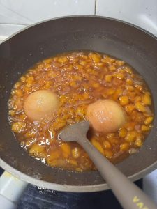 Uncovered jam boiling down to a thick glossy consistency