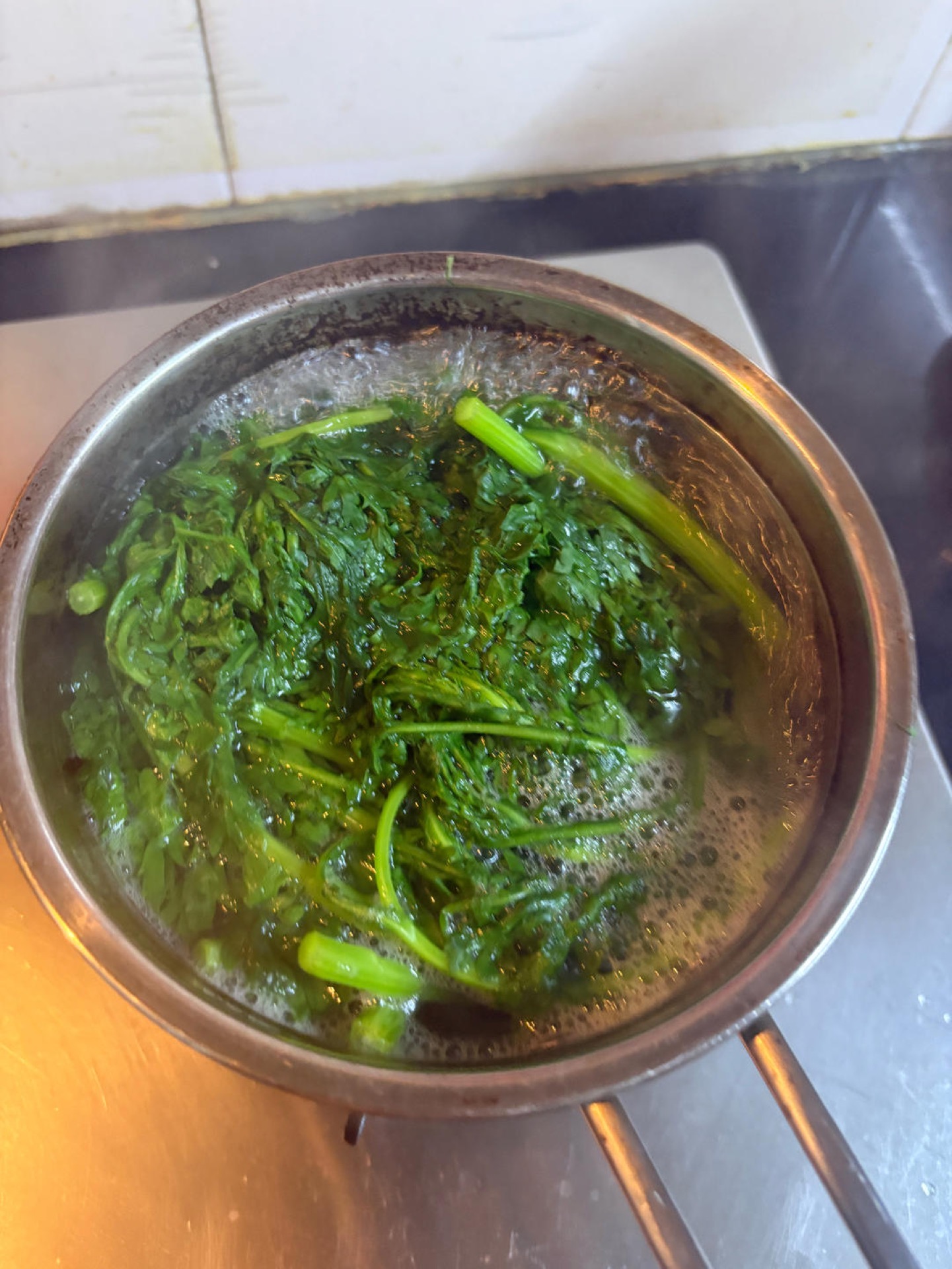 Bring a large pot of water to a rolling boil, add the salt, and cook the greens until just tender — chrysanthemum greens take about 40 seconds from the moment the water returns to