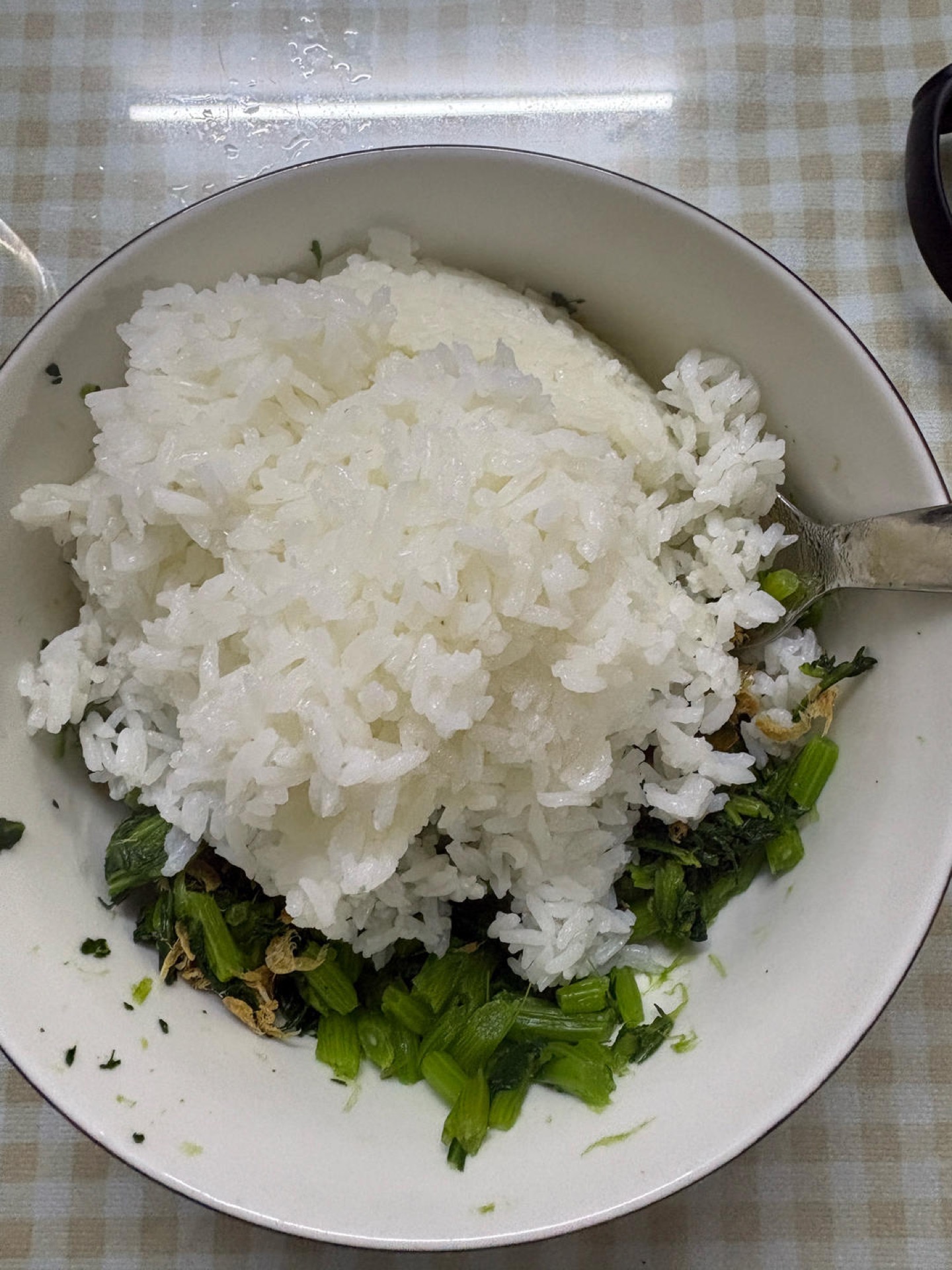 Add the hot cooked rice to the bowl and fold it through the dressed greens until every grain is coated and glossy.