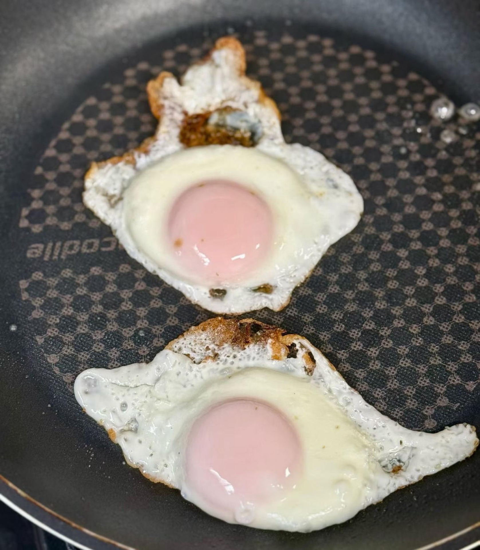 Spray a nonstick pan with a little olive oil and fry the eggs on one side until the yolks are nearly set — adding a splash of water and covering the pan after the eggs go in steams