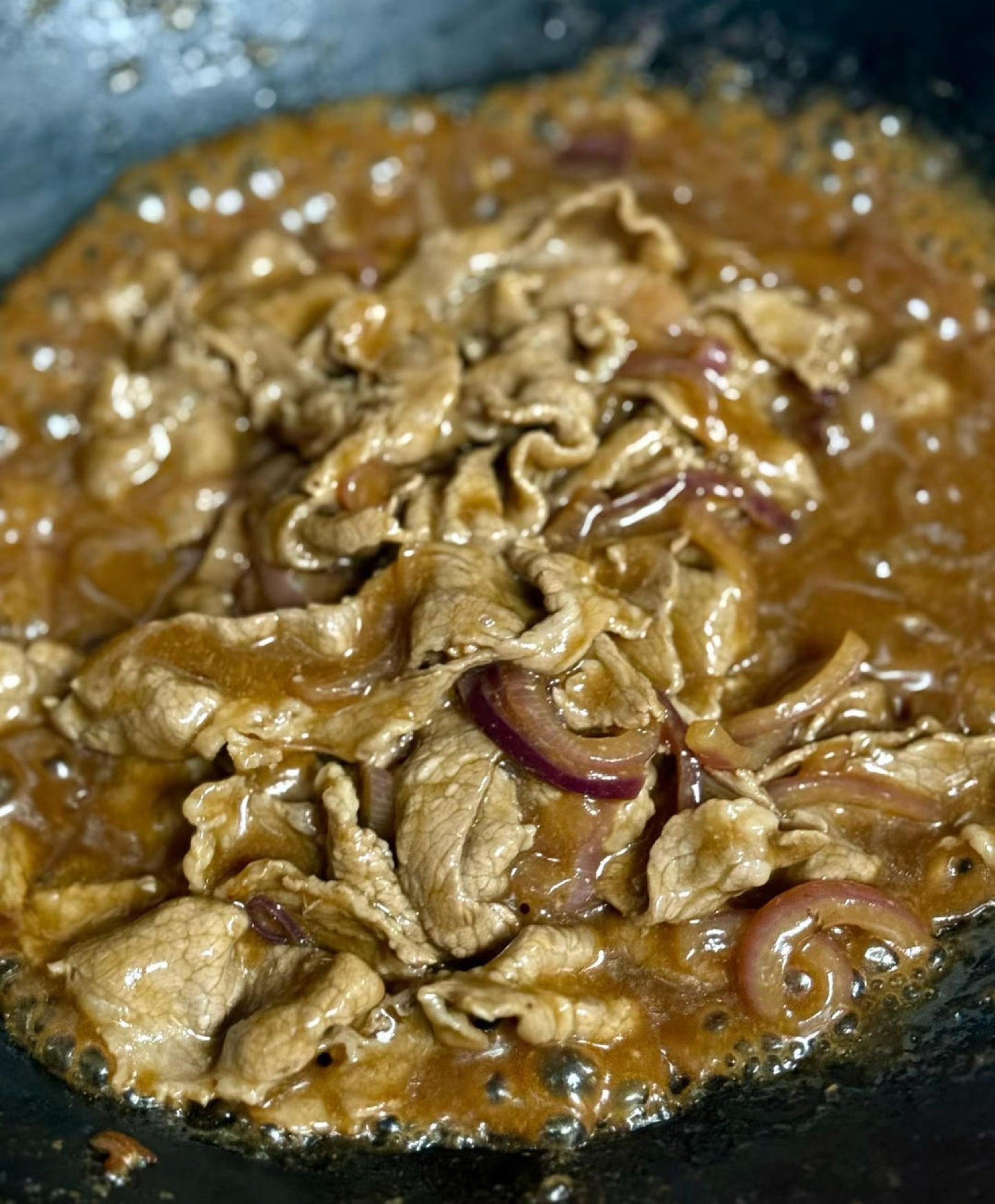 Pour in the sauce you mixed ahead — 2 tablespoons light soy sauce, ½ tablespoon dark soy sauce, 1 tablespoon Shaoxing wine, a pinch of sugar, 1 heaping tablespoon cornstarch, and a