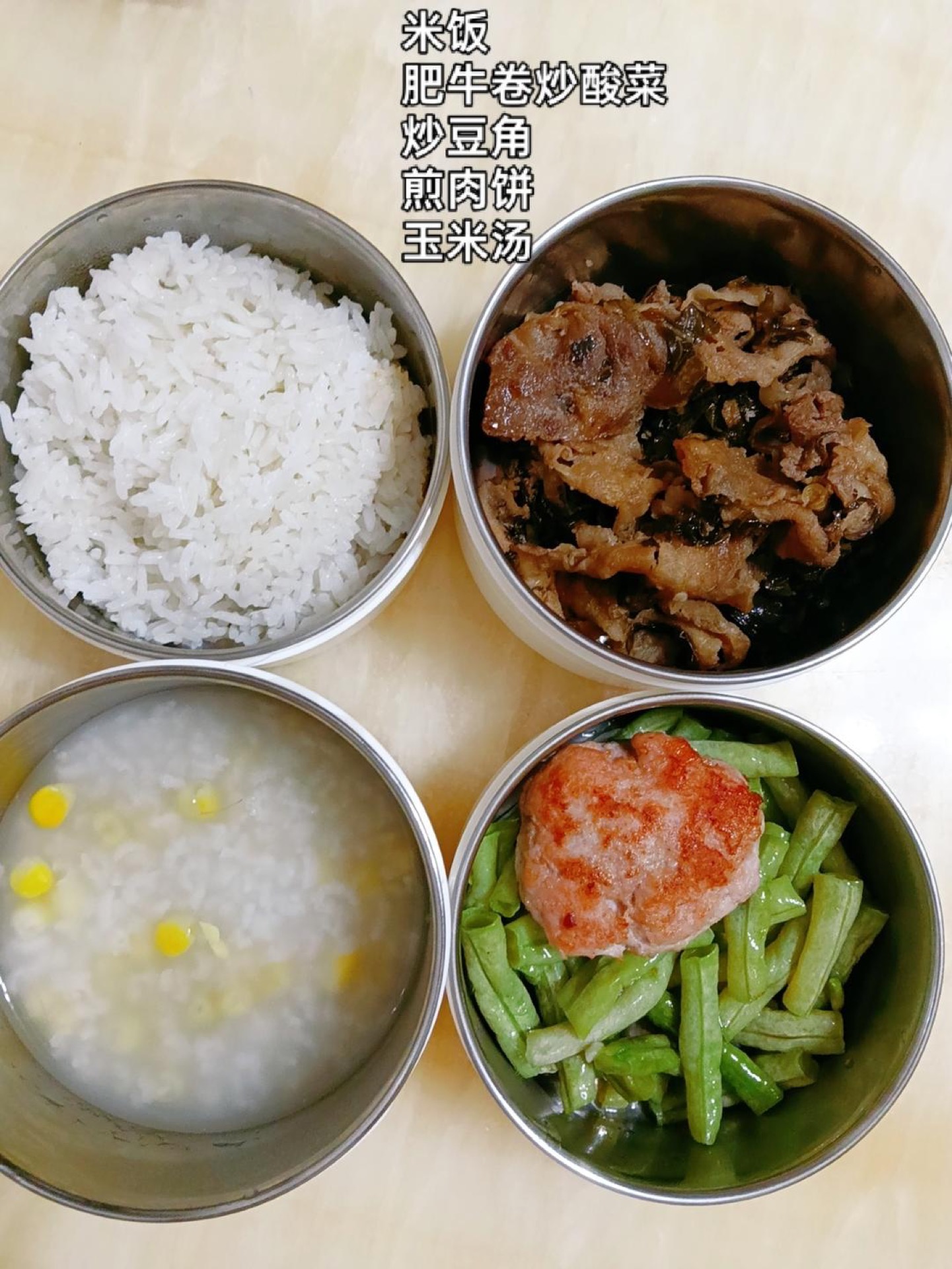 Pack steamed rice with stir-fried beef rolls and pickled mustard greens, stir-fried green beans, a pan-fried pork patty, and a corn soup on the side.