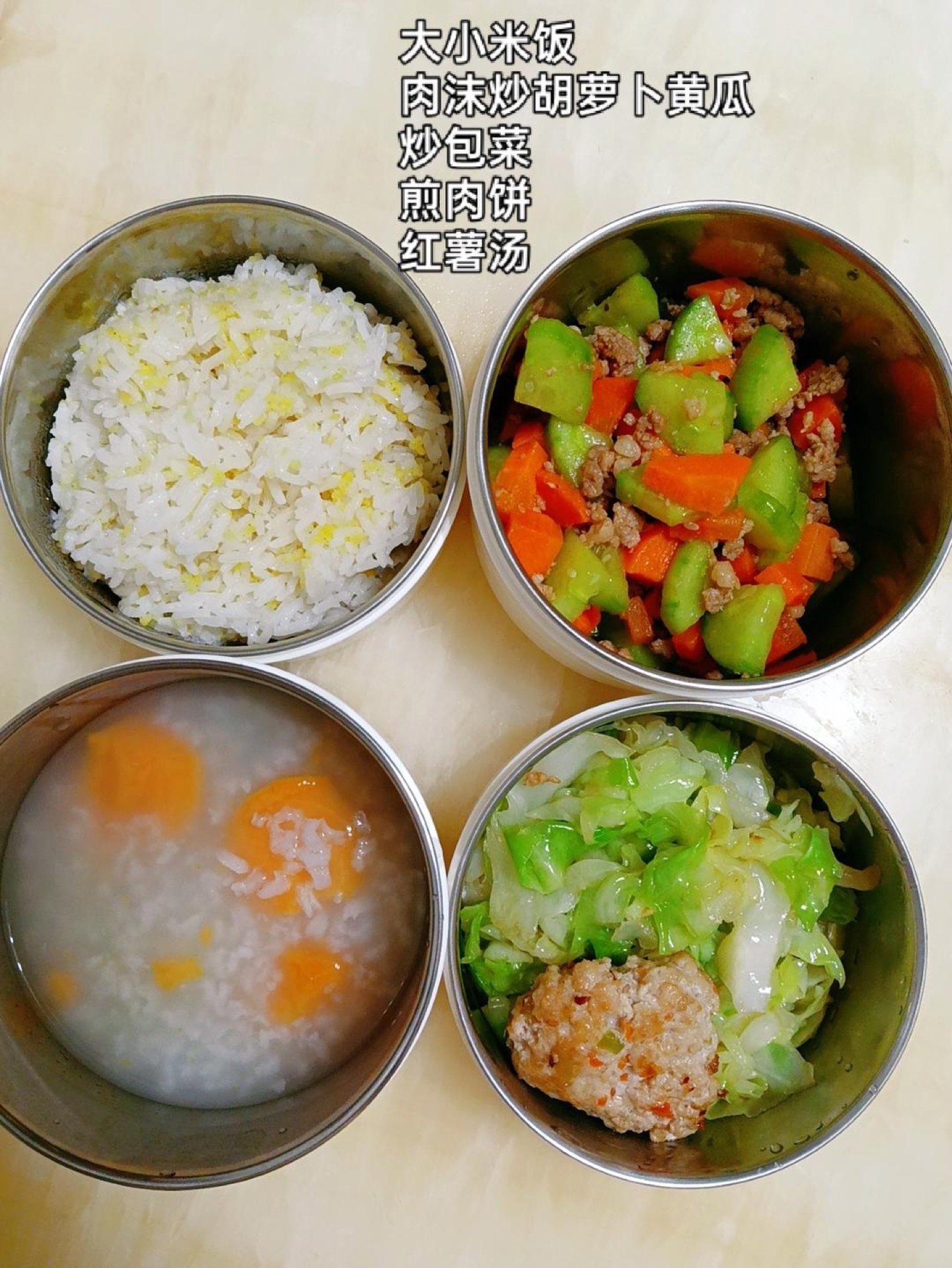 Pack a mixed grain rice, stir-fried minced pork with carrot and cucumber, stir-fried cabbage, a pan-fried pork patty, and a sweet potato soup alongside.