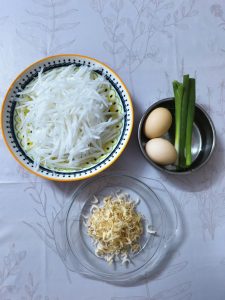 Shred the peeled daikon, beat the eggs with a pinch of salt, and rinse the dried shrimp so everything is ready before the wok heats up.