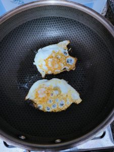 Heat the oil in a wok over medium-high heat and fry the beaten eggs into a flat, golden omelette, then slide it onto a board and cut it into bite-sized pieces.