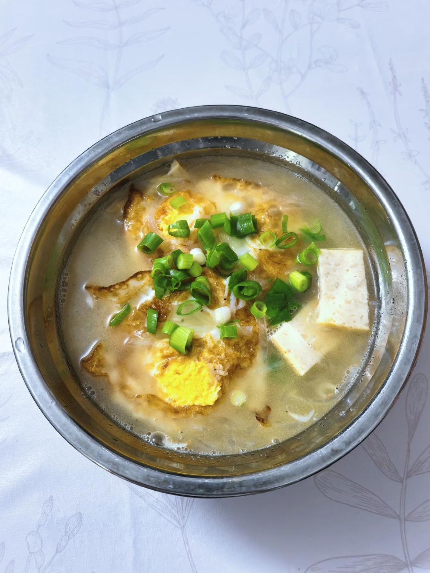 Season with salt and chicken bouillon, taste and adjust, then scatter the chopped scallions over the top and serve hot.