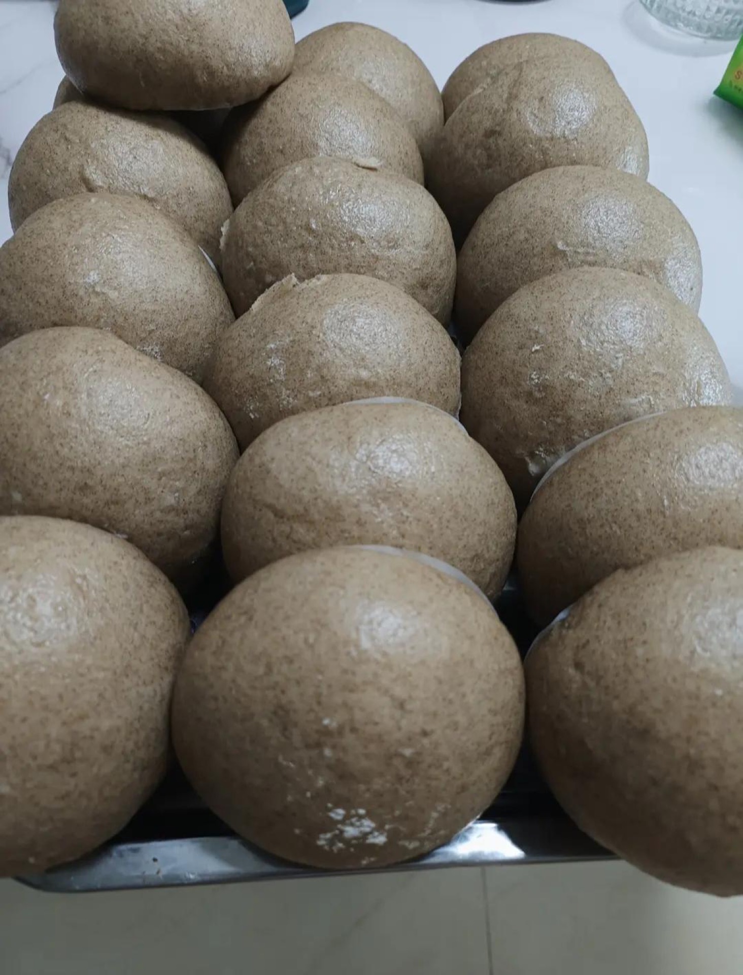 Whole wheat multigrain steamed buns stacked in a bamboo steamer