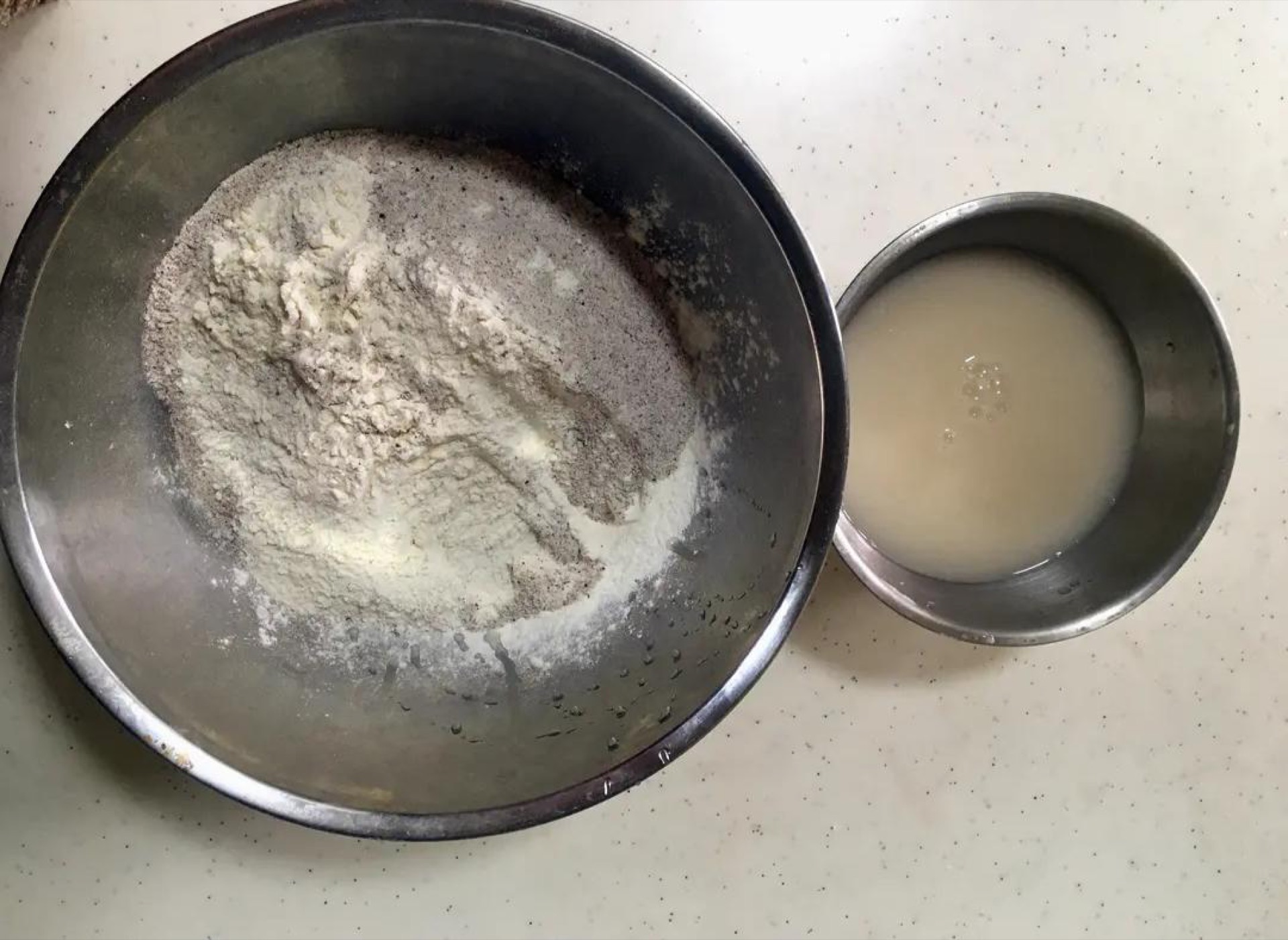 Whisk the yeast and sugar into the warm water and let it sit 3 minutes until foamy, then combine the bread flour and whole wheat flour, pour in the yeast water while stirring into