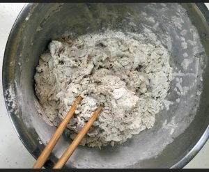 Stir the mixture until no dry flour remains, then turn it out and start kneading the shaggy mass into a cohesive ball.