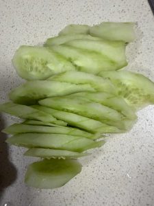 Thin slices of peeled cucumber on a cutting board
