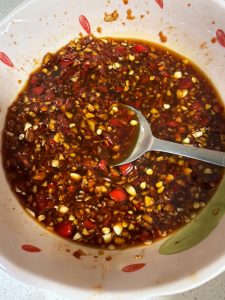 Garlic chili sauce in a small bowl with chopped chilies and garlic