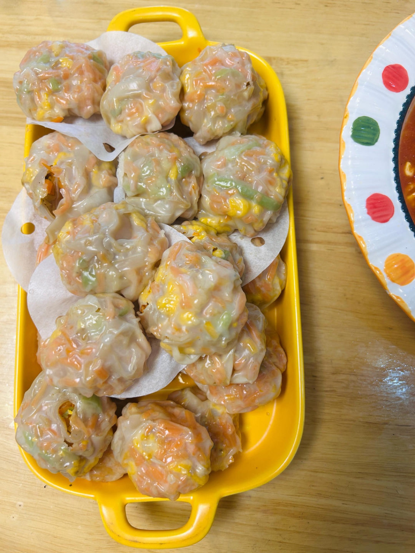 Steamed wonton wrapper dumplings filled with vegetables and egg on a bamboo steamer