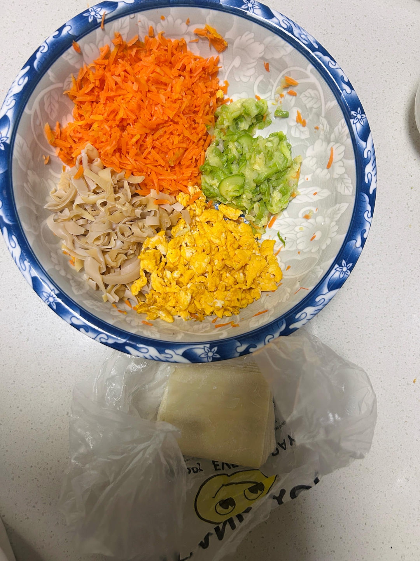 Chopped vegetables and scrambled egg in a mixing bowl