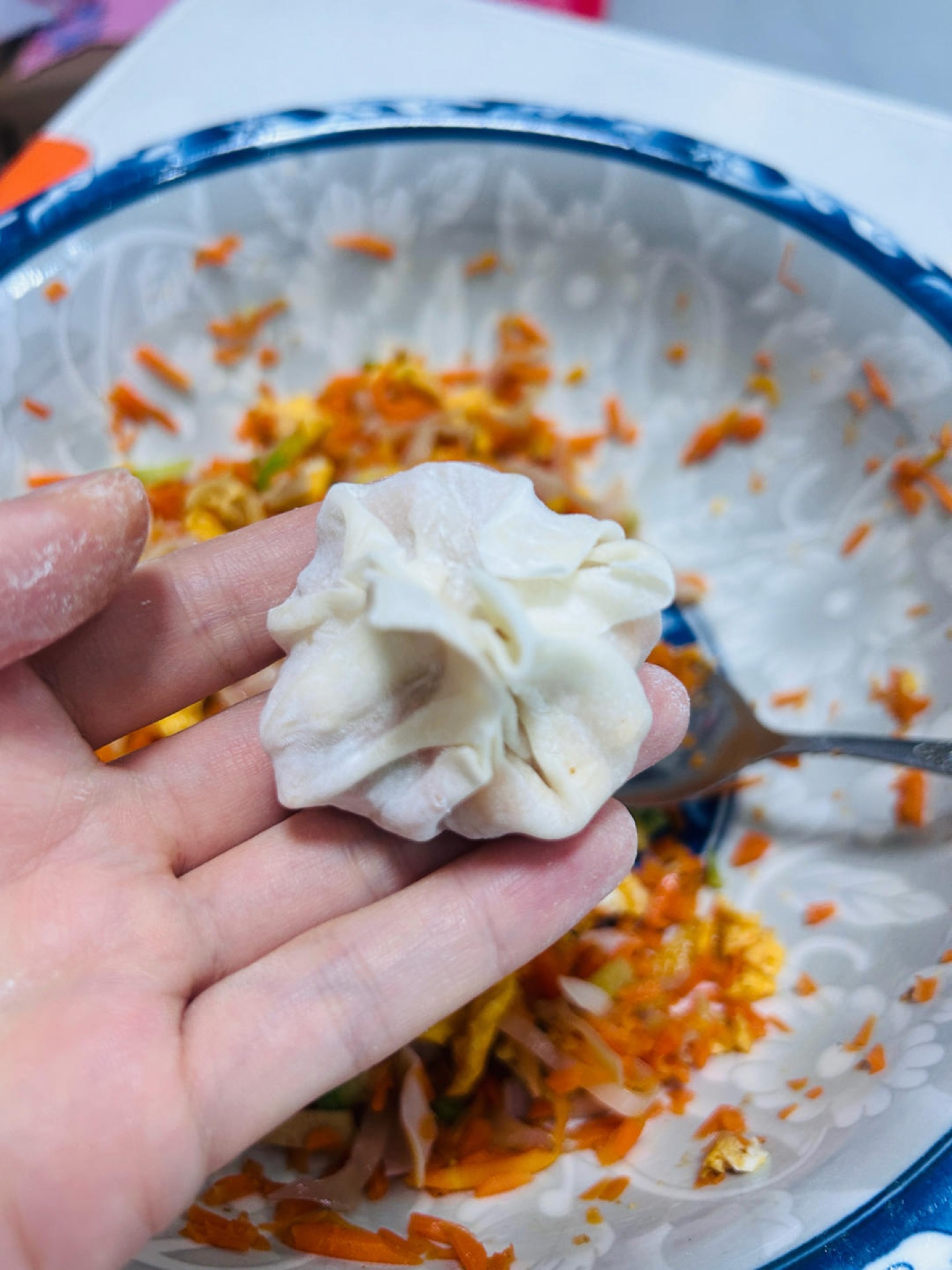 Pinching four corners of a wonton wrapper together