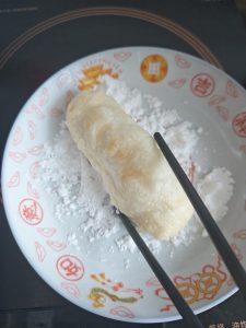 Fried rice cakes rolled in sugar powder