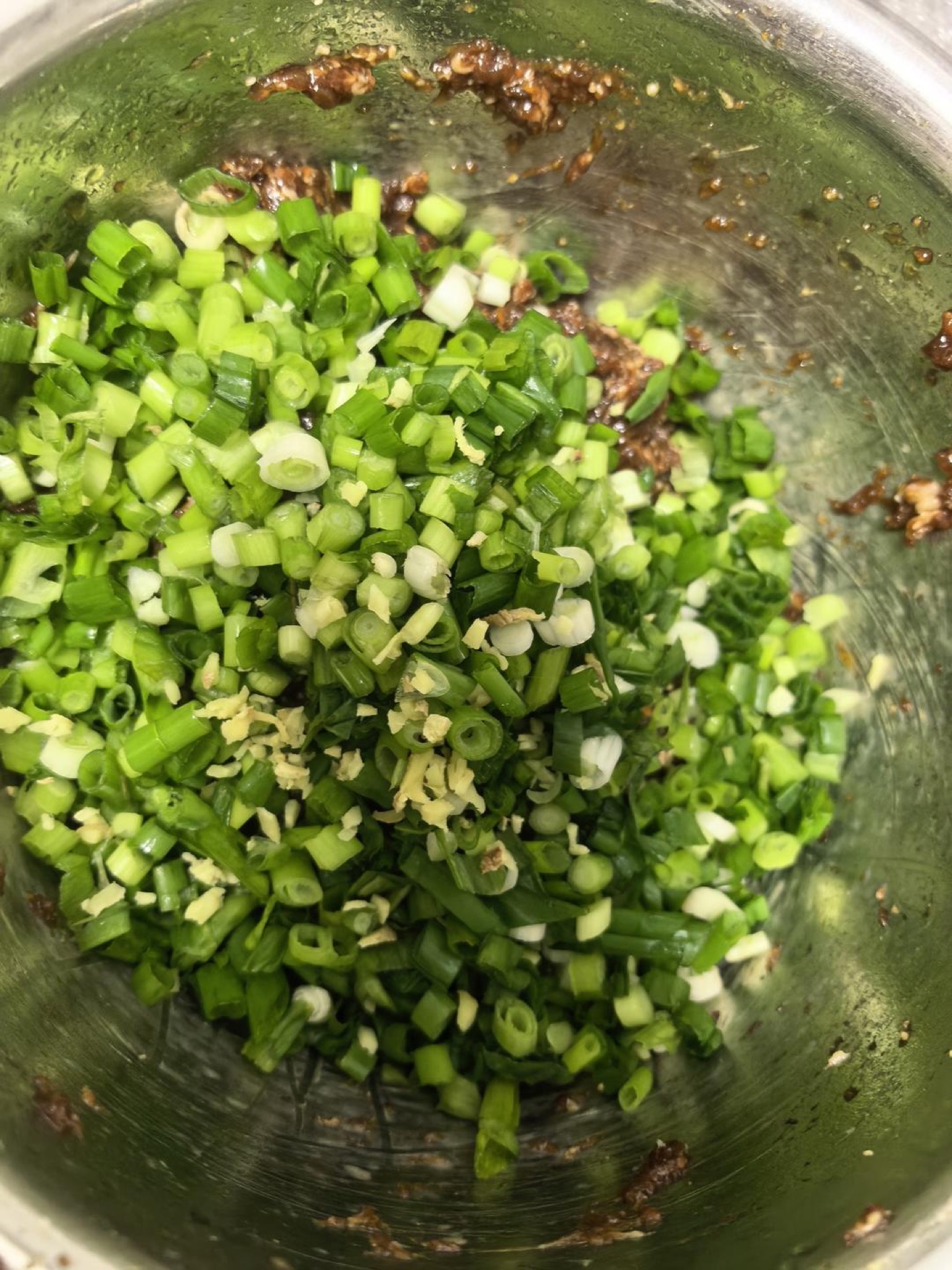 Take the chilled meat out after two hours, then add minced ginger, sliced scallions, and sesame oil, and mix well.
