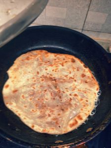 Heat a pan with oil. Place the pie in, cover, and fry for two minutes. Brush the surface with oil, wait until it starts to puff, flip and fry another two minutes. Flip once more an