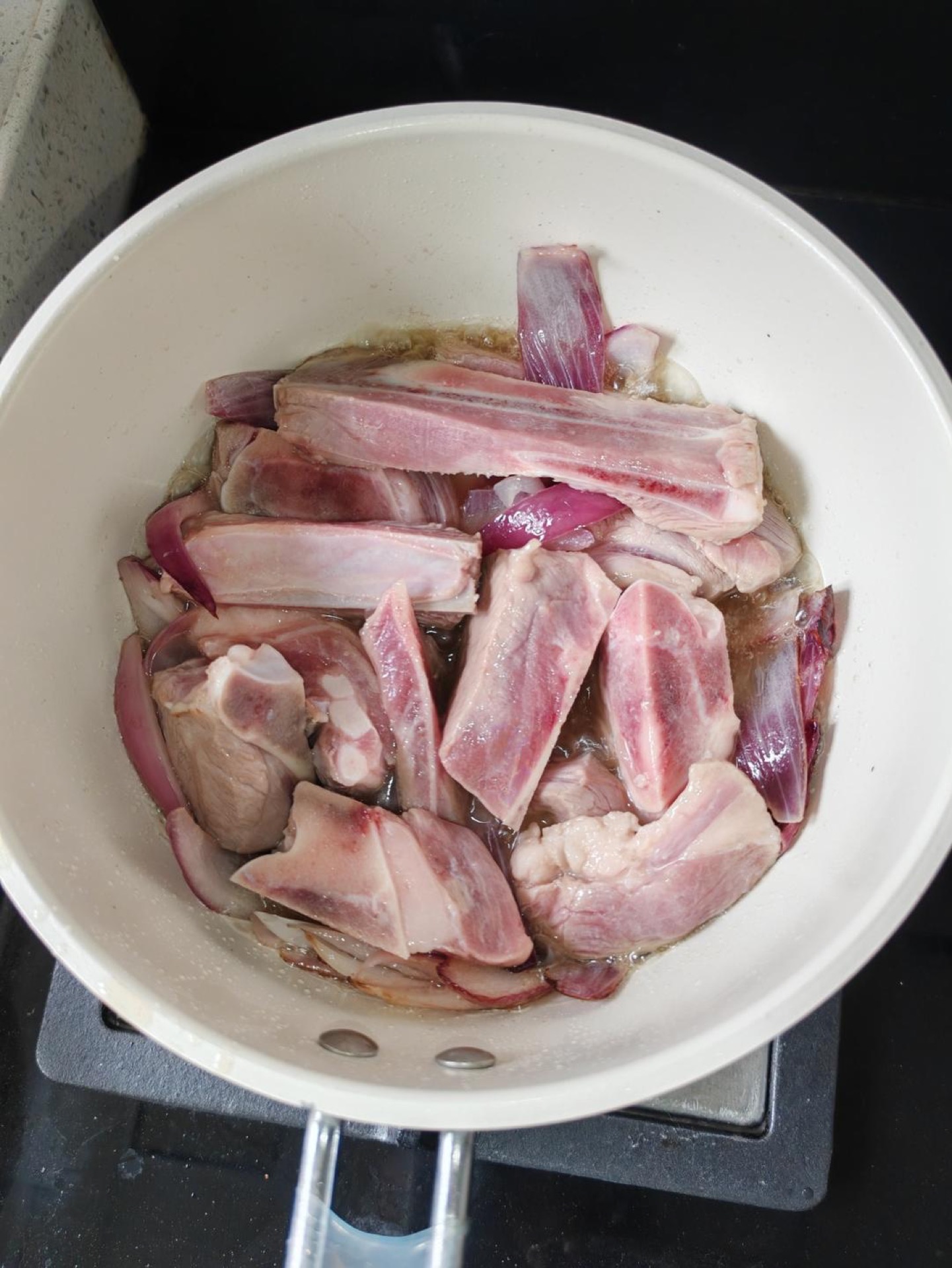 Turn the heat to high and sear the lamb in the onion-infused oil until the surface is golden brown, then add the remaining three quarters of the onion.