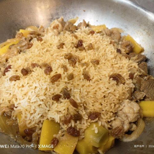 Xinjiang lamb pilaf with tender lamb, carrots, and rice in a wok