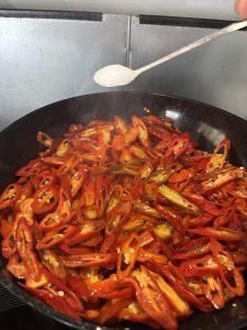 Chile slices frying in oil with salt