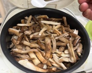 Mushrooms pre-cooking in the rice cooker with salt