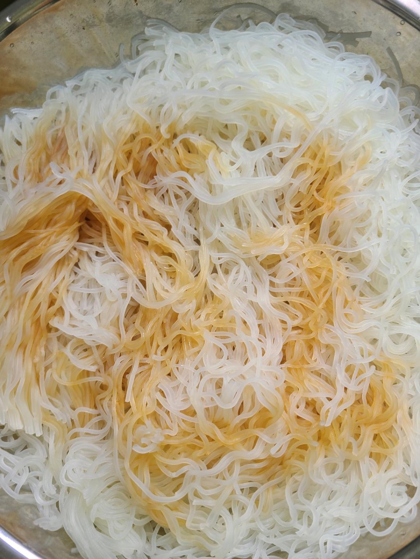 Lift the softened rice noodles out of the water and drain well, then add light soy sauce and peanut oil and toss gently to coat, adding a tiny pinch of salt if you like.
